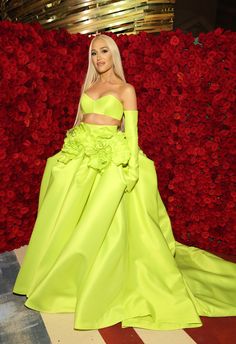 lady in lime green gown standing next to red roses