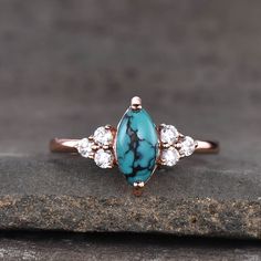 a turquoise stone ring with three diamonds on it