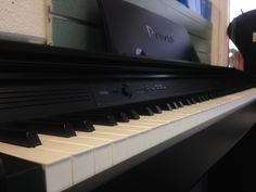 a black piano sitting in front of a laptop computer