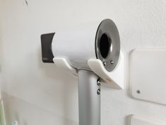 a white wall mounted toilet paper dispenser on the side of a bathroom