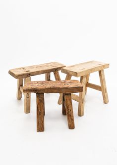 three wooden benches sitting next to each other on a white surface with one bench made out of wood