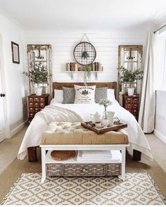 a bedroom with white walls and wooden furniture, including a large bed covered in linens