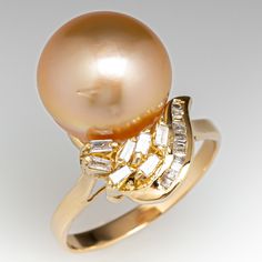 This striking ring is centered with one (1), post set, golden cultured South Sea pearl and is accented with eighteen (18), prong/channel set, baguette cut diamonds. The ring measures 18.8mm at the top, rises 14.7mm above the finger, tapering to 2.2mm wide and 0.6mm thick at the base of the shank. This ring is currently a size 6.5. Luxury Oval Pearl Ring With Prong Setting, Luxury Elegant Pearl Ring With Bezel Setting, Luxury Timeless Pearl Ring With Polished Finish, Luxury Classic Open Pearl Ring, Luxury Pearl Ring With Single Cut Diamonds For Anniversary, Luxury Pearl Ring With Prong Setting For Anniversary, Luxury Diamond Pearl Ring, Wide Band Diamond Rings, Weddings Ring