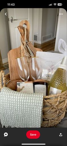 a wicker basket filled with wine glasses and other items on top of a bed