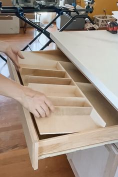 a person is opening the drawers on a desk