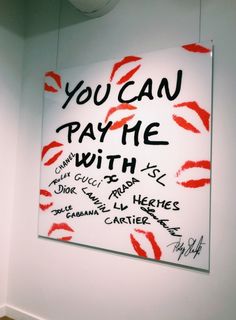 a sign that says you can pay the with red lipstick on it in front of a white wall