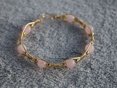 Check out this beautiful hand wrapped bracelet with a harmonious blend of elegance and charm. Genuine rose quartz beads, known for their soothing energy, are delicately accented by hand wrapped gold-colored wire (tarnish resistant copper wire). Elevate your style with the timeless beauty of natural gemstones and handcrafted artwork. How To Make Gemstone Bracelets, Wire Wrapped Beaded Bracelet, Wire Wrapped Pearl Bracelet, Gold Wire Bracelet, Braided Wire Bracelet, Bead Wire Bracelet, Dainty Wire Wrapped Jewelry, Cute Homemade Bracelets, Homemade Charm Bracelets