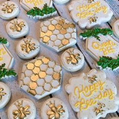 many decorated cookies on a table with green leaves and honeycombs in the shape of hexagons