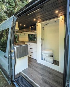 the interior of a van with its door open and it's toilet in the back