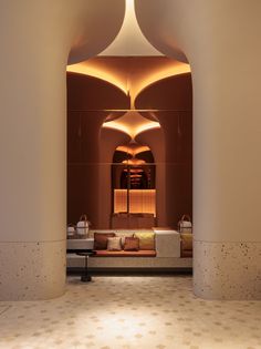 the interior of a modern hotel lobby with large columns and lights on either side of the room