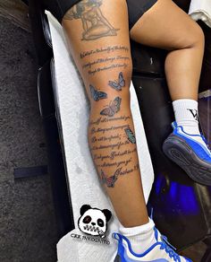 a person with tattoos on their legs sitting in a chair