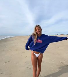 a woman standing on top of a sandy beach