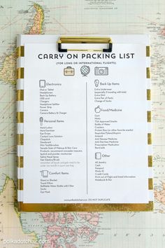 the carry on packing list is placed on top of a world map with gold pins