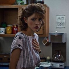 a woman standing in a kitchen next to a counter