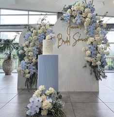 a blue and white wedding cake surrounded by flowers