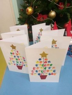 several cards with different designs on them sitting in front of a christmas tree and presents