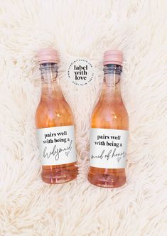 two bottles of caramel wine sitting on top of a white blanket next to each other