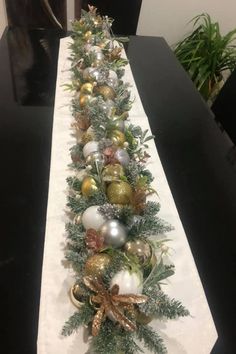 a long table with ornaments and greenery on it