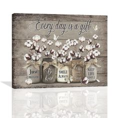 a wooden sign that says every day is a gift with three mason jars filled with flowers