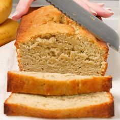 a loaf of banana bread being sliced with a knife