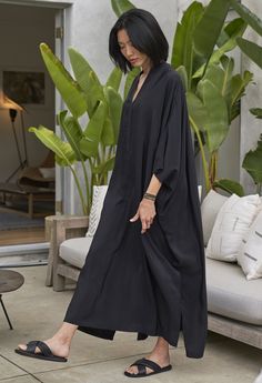 Eco friendly caftans and tunics inspired by the ocean, made on main street. Ethically sourced and locally made in Los Angeles. No caftan collection would be complete without a nod to the inimitable Talitha Getty. The ultimate in laid-back glamour, our luxurious Talitha caftan is a chic as it gets. With a delicate collar, a slightly longer 'sleeve' and loads of sumptuous silk, this is the quintessential caftan silhouette. The deep, low pleat in the back adds a modern flair and the side slits prov Oversized Long Sleeve Abaya For The Beach, Black Abaya For Beach, Oversized Long Abaya For The Beach, Black Caftan, Talitha Getty, Silk Caftan, Baddie Vibes, By The Ocean, Black Silk