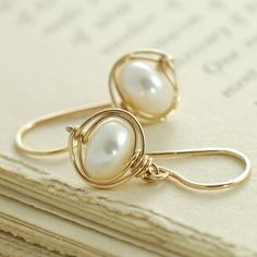 Lustrous white pearls are wrapped with 14k gold filled wire in these simple yet stunning earrings. These are extremely versatile and are easily dressed Elegant Wire Wrapped Wrap Earrings As Gift, Elegant 14k Gold Filled Wrap Earrings For Gift, Elegant 14k Gold Filled Wrap Earrings As Gift, Elegant Wire Wrapped Earrings For Everyday, Elegant Everyday Wire Wrapped Earrings, Dainty Wire Wrapped Pearl Earrings In 14k Gold, Dainty Wire Wrapped Pearl Earrings As Gift, Elegant Gold Wire Wrapped Wrap Earrings, Dainty Wire Wrapped Pearl Earrings For Gift