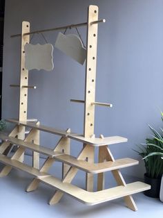 a wooden bench sitting next to a mirror on top of a shelf in front of a potted plant