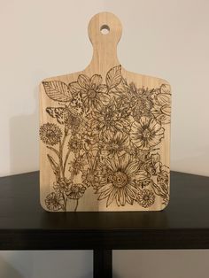 a wooden cutting board with flowers on it