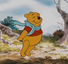 winnie the pooh is standing in front of some trees and looking up at something