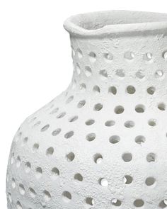 a white vase with holes in it