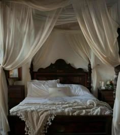 the canopy bed is made up with white drapes