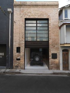 the car is parked in the garage on the side of the building with its door open