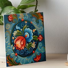 an artistic painting on a blue background with flowers and swirls in the center art board print