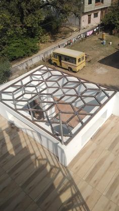 an aerial view of a building with a bus in the background