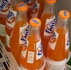 several orange soda bottles are lined up in a cooler