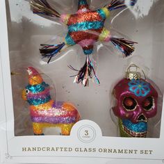 two glass ornaments in the shape of a horse and a skull are shown inside a box