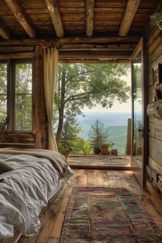 a bedroom with a large window overlooking the valley and mountains is shown in this image