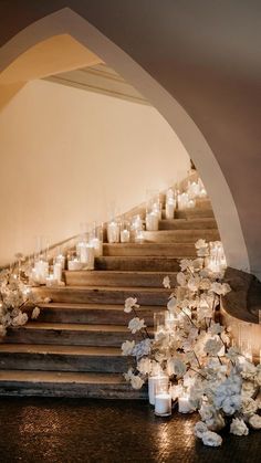 candles are lit on the steps leading up to an aisle with white flowers and hydranges