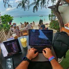 a man sitting at a table using a laptop computer