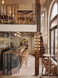 the interior of a restaurant with stools and tables