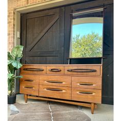 a large wooden dresser sitting in front of a door with a mirror on top of it