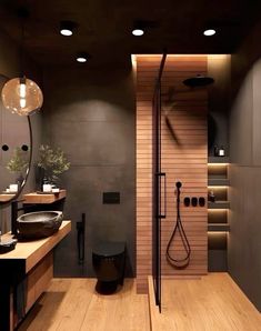 a modern bathroom with wooden floors and black fixtures on the walls, along with an open shower