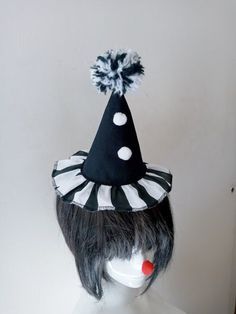 a mannequin head wearing a black and white clown hat