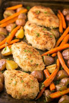 chicken, potatoes and carrots in a pan with seasoning sprinkled on top