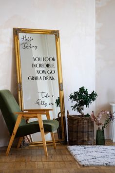 a chair sitting in front of a mirror with writing on it next to a potted plant