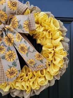 a yellow sunflower wreath with burlocks and ribbons on a black front door