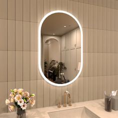 a bathroom with a sink, mirror and flowers in the vase on the counter top