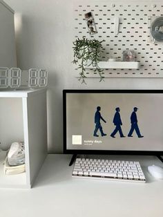 a computer monitor sitting on top of a white desk next to a keyboard and mouse