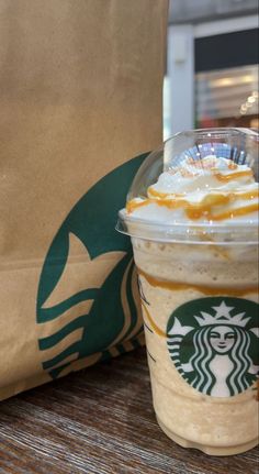 a starbucks drink sitting on top of a wooden table