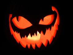 a carved pumpkin with glowing eyes in the dark